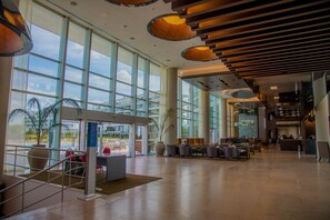 A spacious lobby with large windows, a reception desk, and modern lighting fixtures. - Hilton Pilar (Fátima)