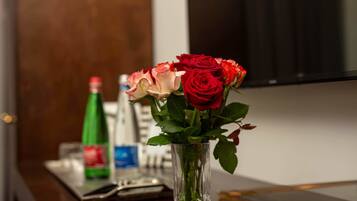 Un vase en verre contenant des roses rouges et roses, posé sur une table en bois.