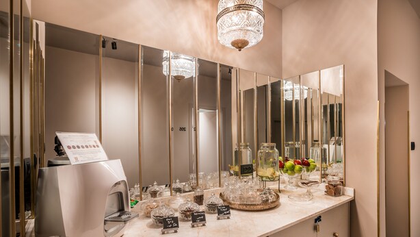 A modern bathroom with a large mirror, a coffee machine, and various toiletries on the counter. - Lear Sense - Experience Luxury Hotel (Gedera)