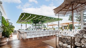 A bar area with a green canopy, white bar stools, and a bar counter. - Lear Sense - Experience Luxury Hotel (Gedera)