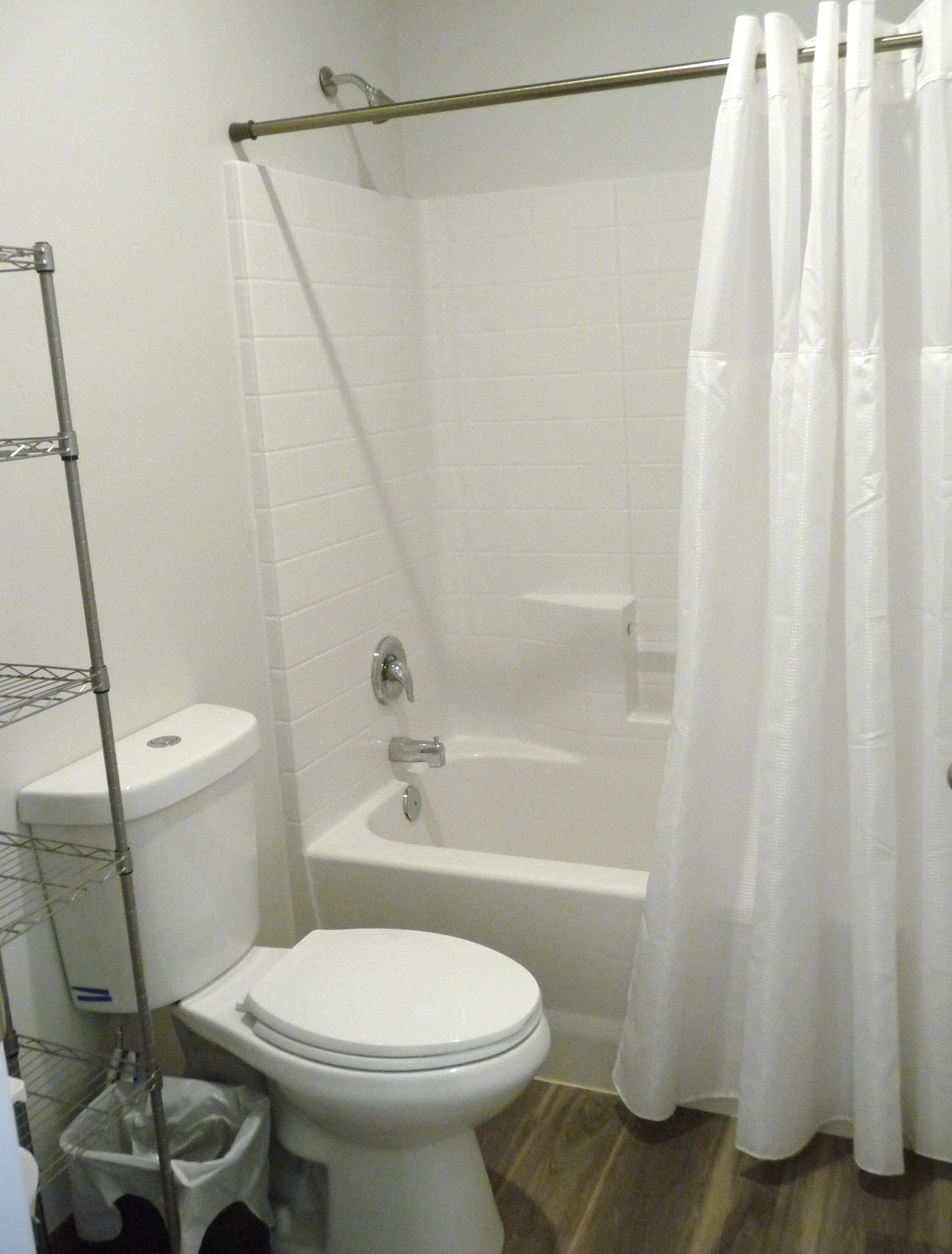A bathroom with a toilet, bathtub, and shower curtain.