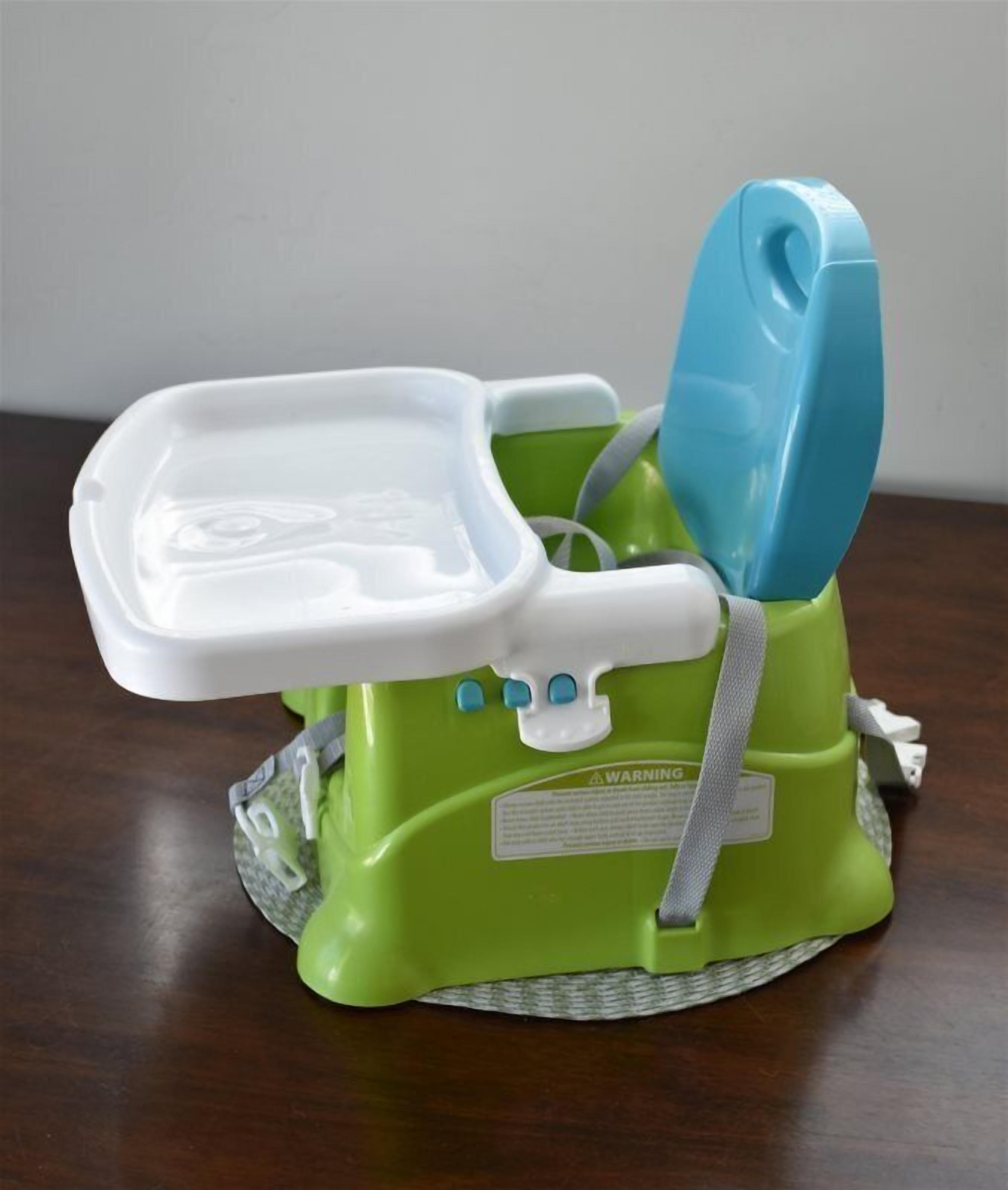 A green and white baby walker with a tray and a blue seat.