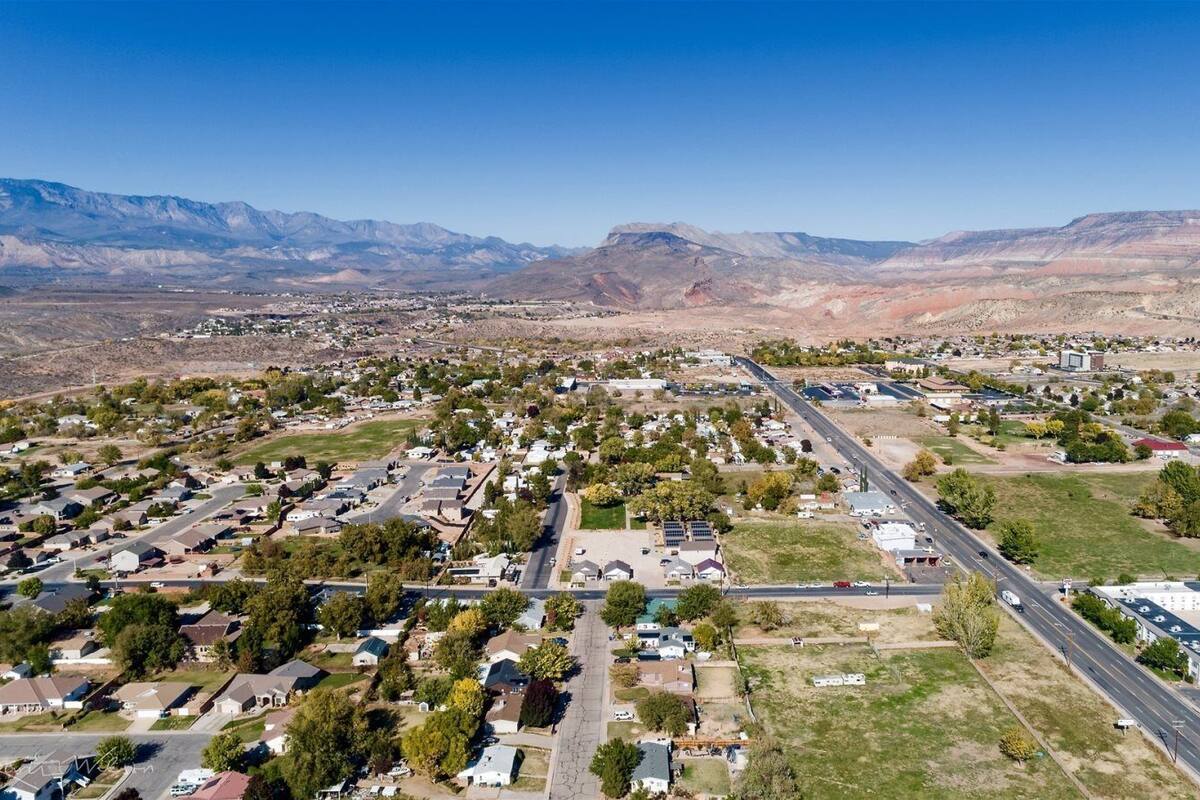 An aerial view of a residential area with houses, roads, and a large building complex.