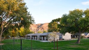 A residential area with houses, a grassy field, and trees. - Zion's Camp and Cottages (La Verkin)
