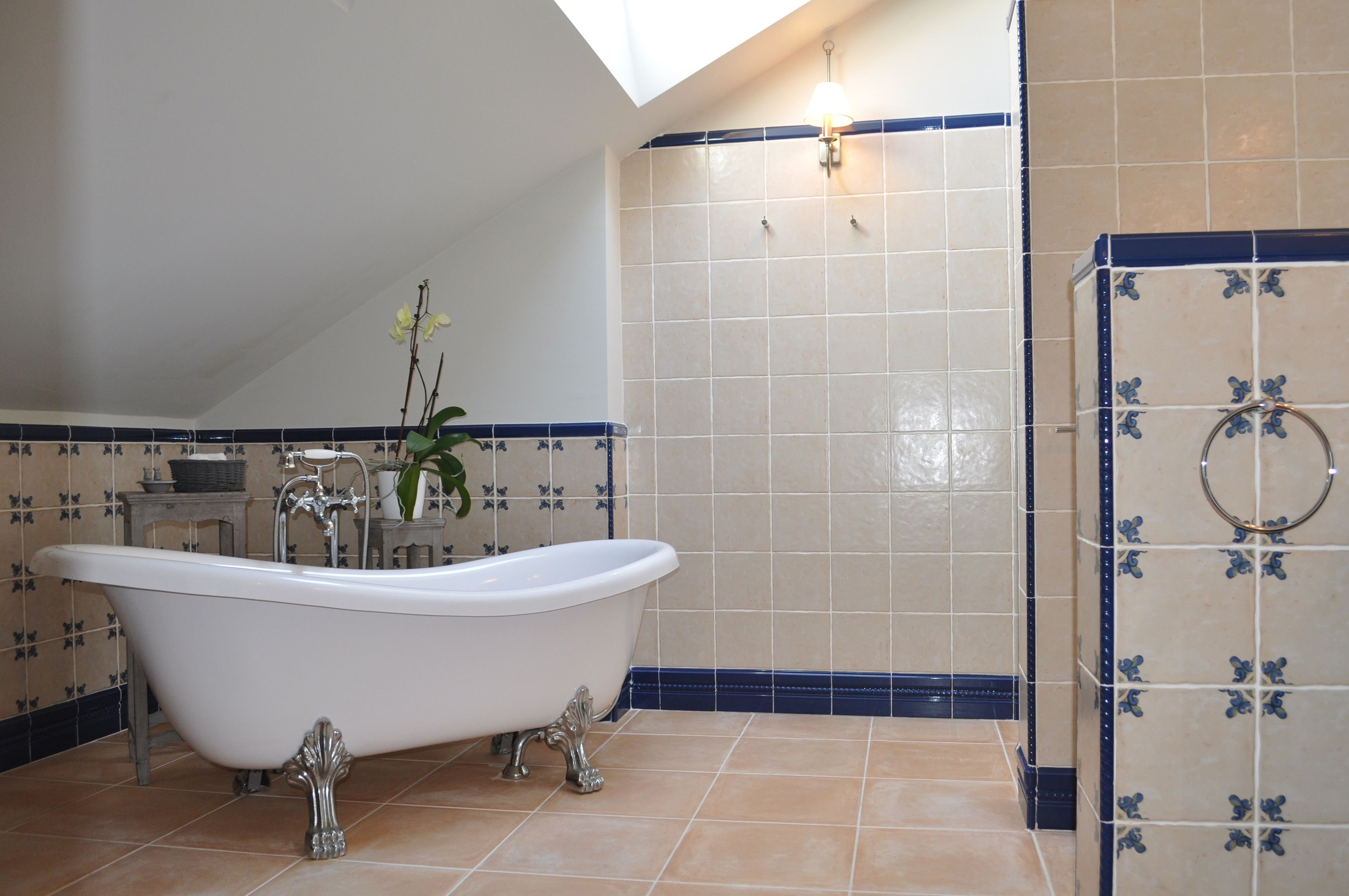 A bathroom with a freestanding bathtub, a towel rack, and a wall-mounted light fixture.