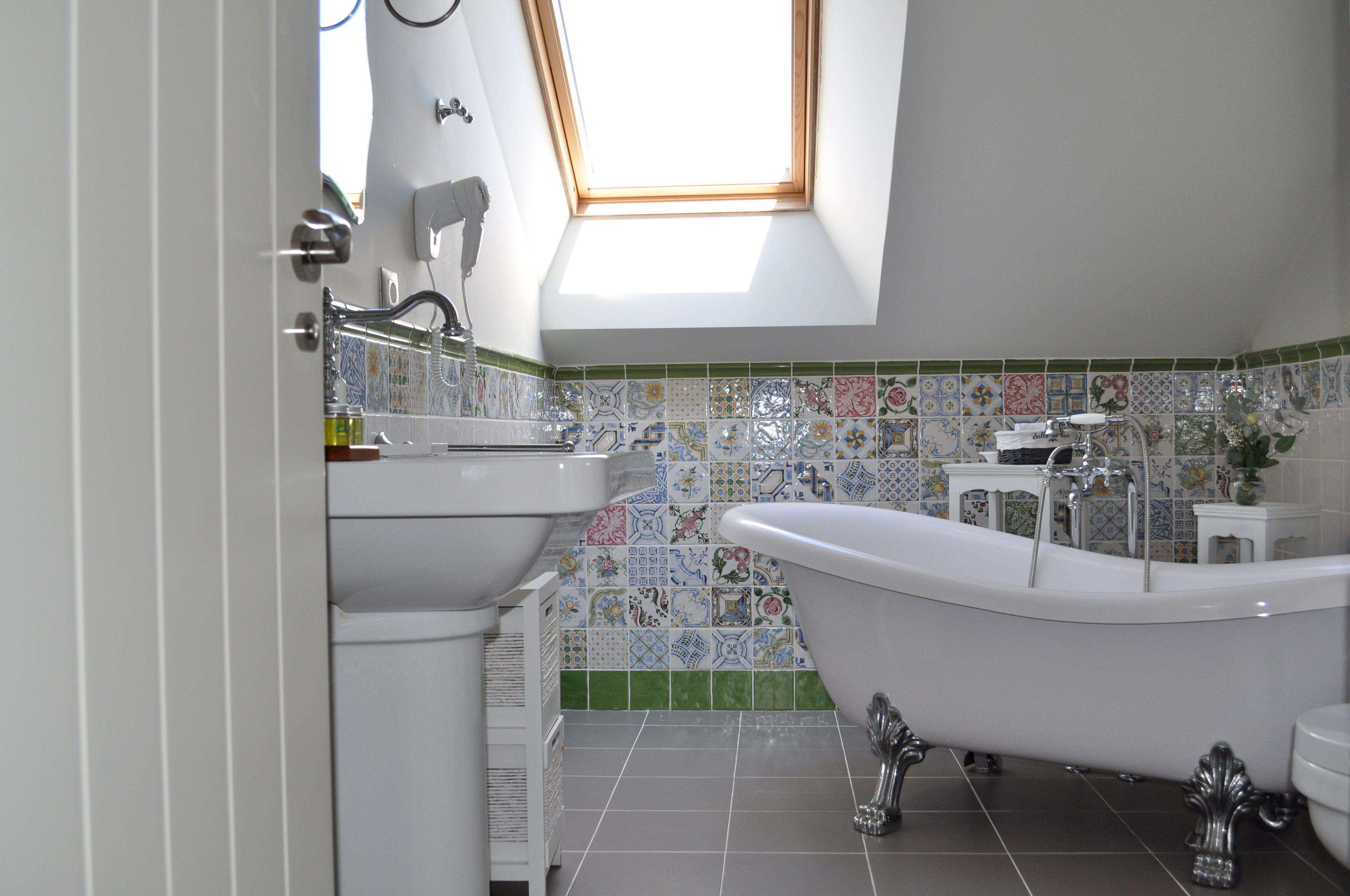 Un baño con bañera independiente, lavamanos y retrete.