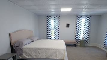 Un dormitorio con cama, un banco, una mesita y una silla.