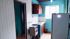 A kitchen with wooden cabinets, a sink, and a refrigerator. - El Rinconcito (Puerto Iguazú)