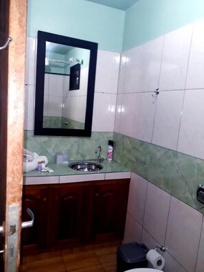 A small bathroom with a sink, mirror, and toilet. - El Rinconcito (Puerto Iguazú)