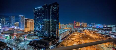 A nighttime cityscape with illuminated skyscrapers, including a prominent Hilton Grand Vacations building.