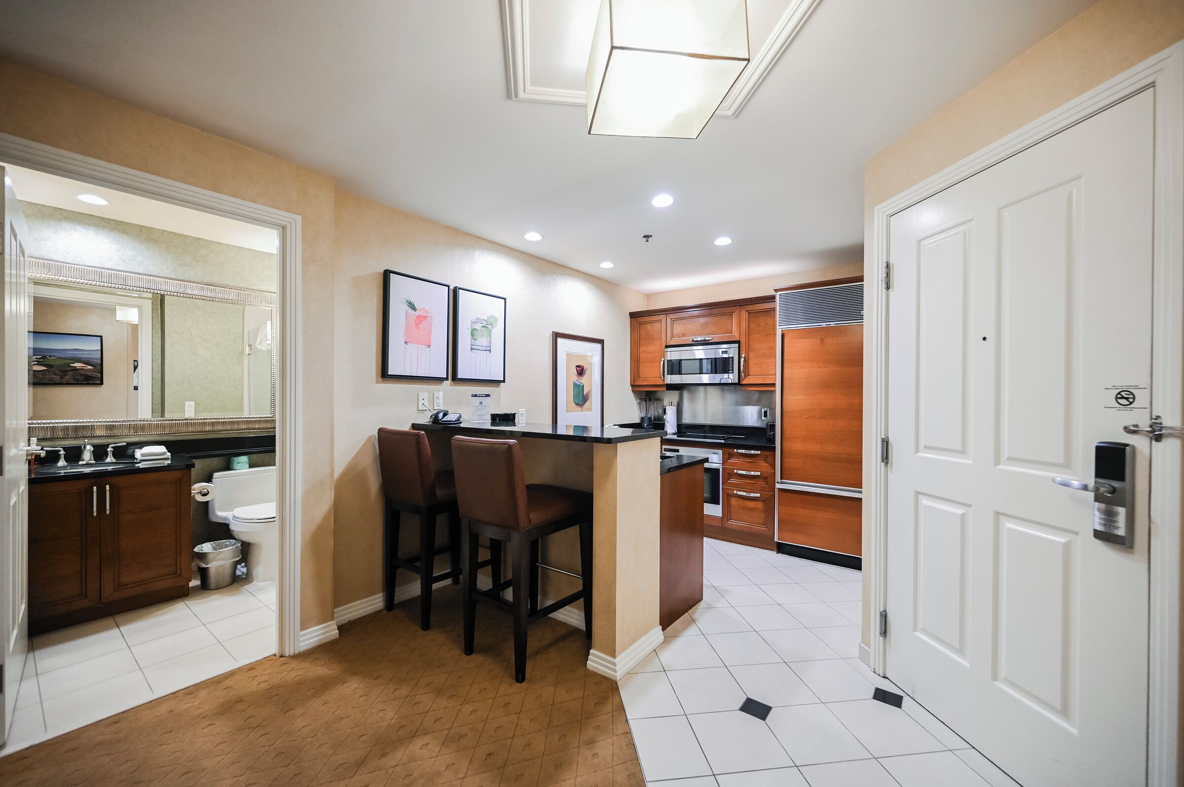 A compact kitchen with a central island, wooden cabinets, and a microwave.