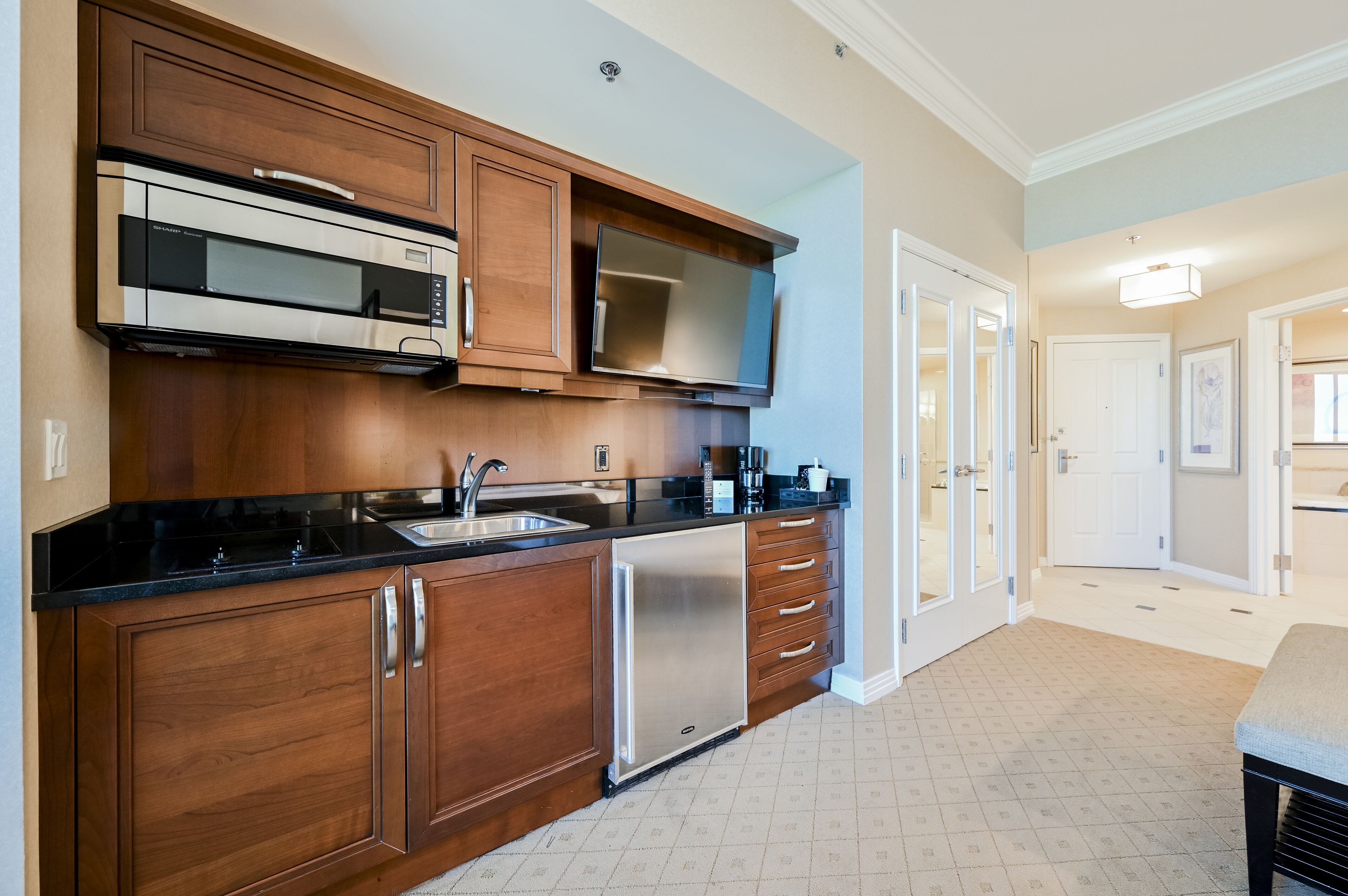 A kitchen with wooden cabinets, stainless steel appliances, and a black countertop.