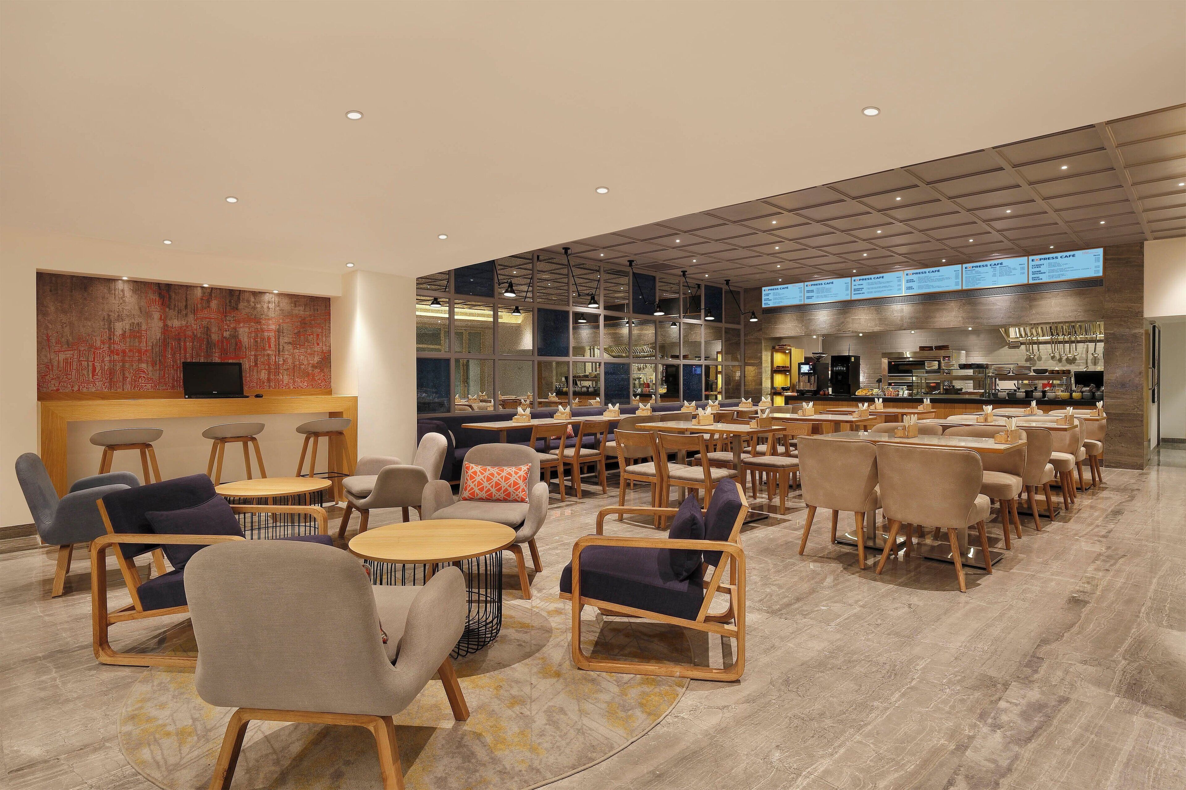 A spacious cafe with multiple seating areas, a counter, and a menu board.