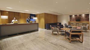 A modern reception area with a reception desk, seating area, and a large wall-mounted TV. - Holiday Inn Express Bengaluru Yeshwantpur by IHG (Bengaluru)