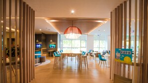 Un comedor moderno con suelo de madera, una mesa central y sillas azules.