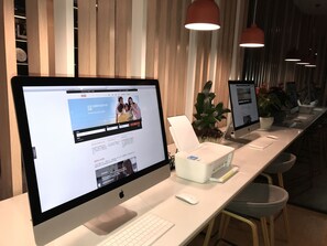A modern office space with Apple iMac computers, a white desk, and a keyboard. - Holiday Inn Express Hefei High Tech by IHG (Hefei)