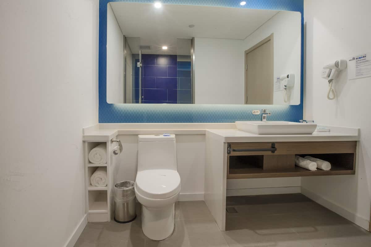A modern bathroom with a toilet, sink, and mirror.