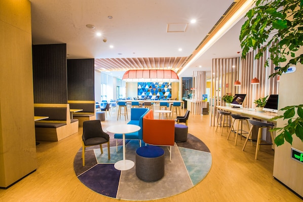A modern lounge area with seating arrangements, a central table, and a bar area. - Holiday Inn Express Hefei High Tech by IHG (Hefei)