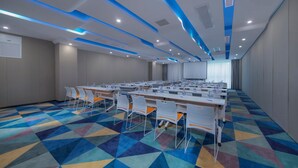 A conference room with a long table, chairs, and a projector screen.