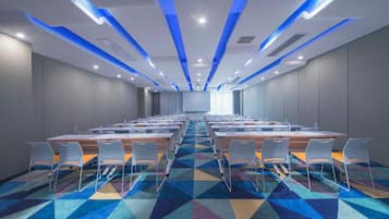 A conference room with a long table, chairs, and a patterned carpet.