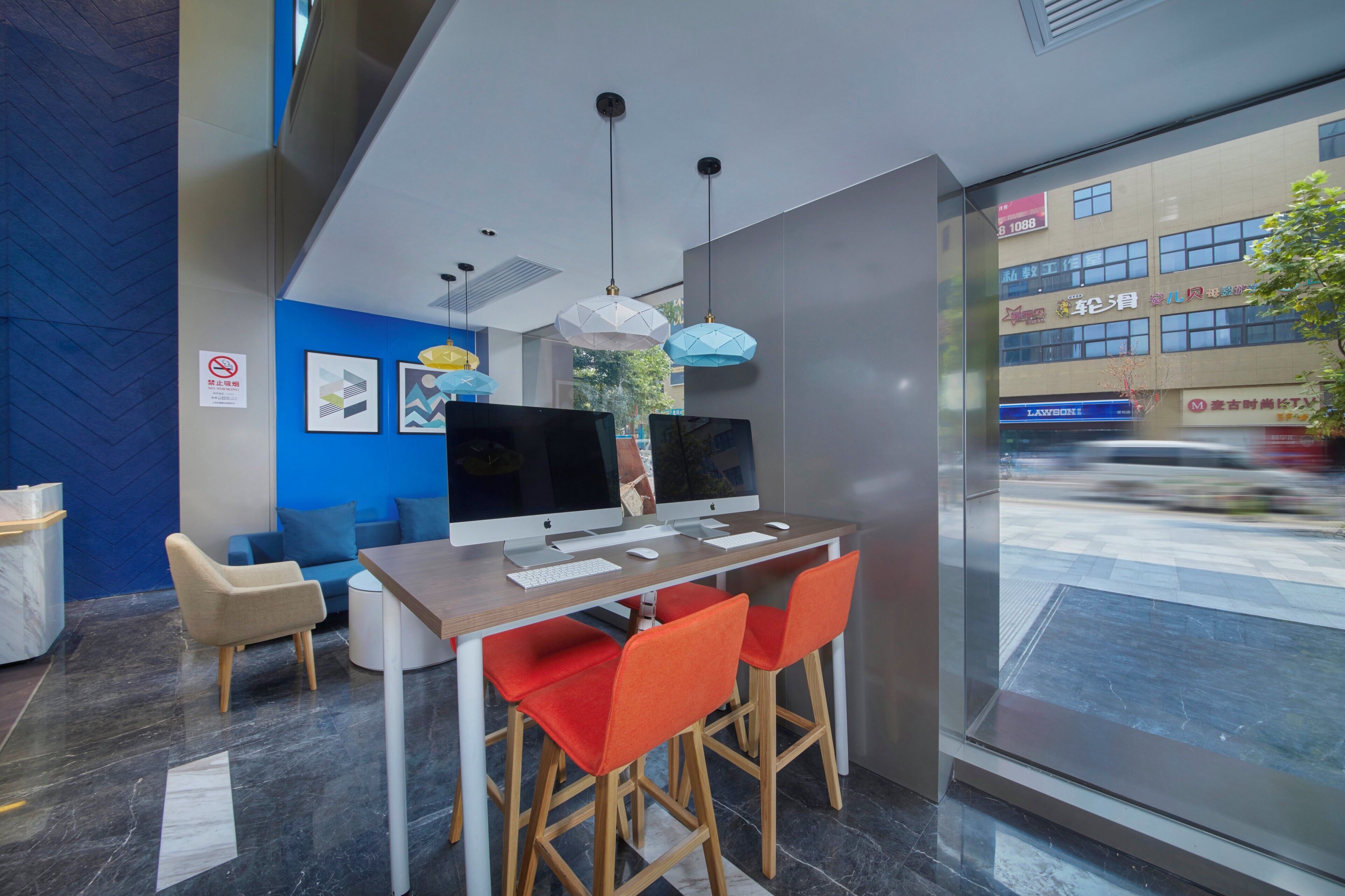 A modern office space with a desk, computer, and chairs.