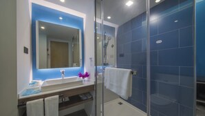 A modern bathroom with a glass-enclosed shower, a large mirror, and a white sink. - Holiday Inn Express Shanghai Jinshan by IHG (Shanghai)