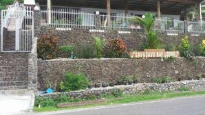 Un muro de piedra con un letrero que indica 'Savusavu Bay Lodge'.