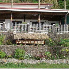 Señal del Savusavu Bay Lodge, con techo de paja y pared de piedra.