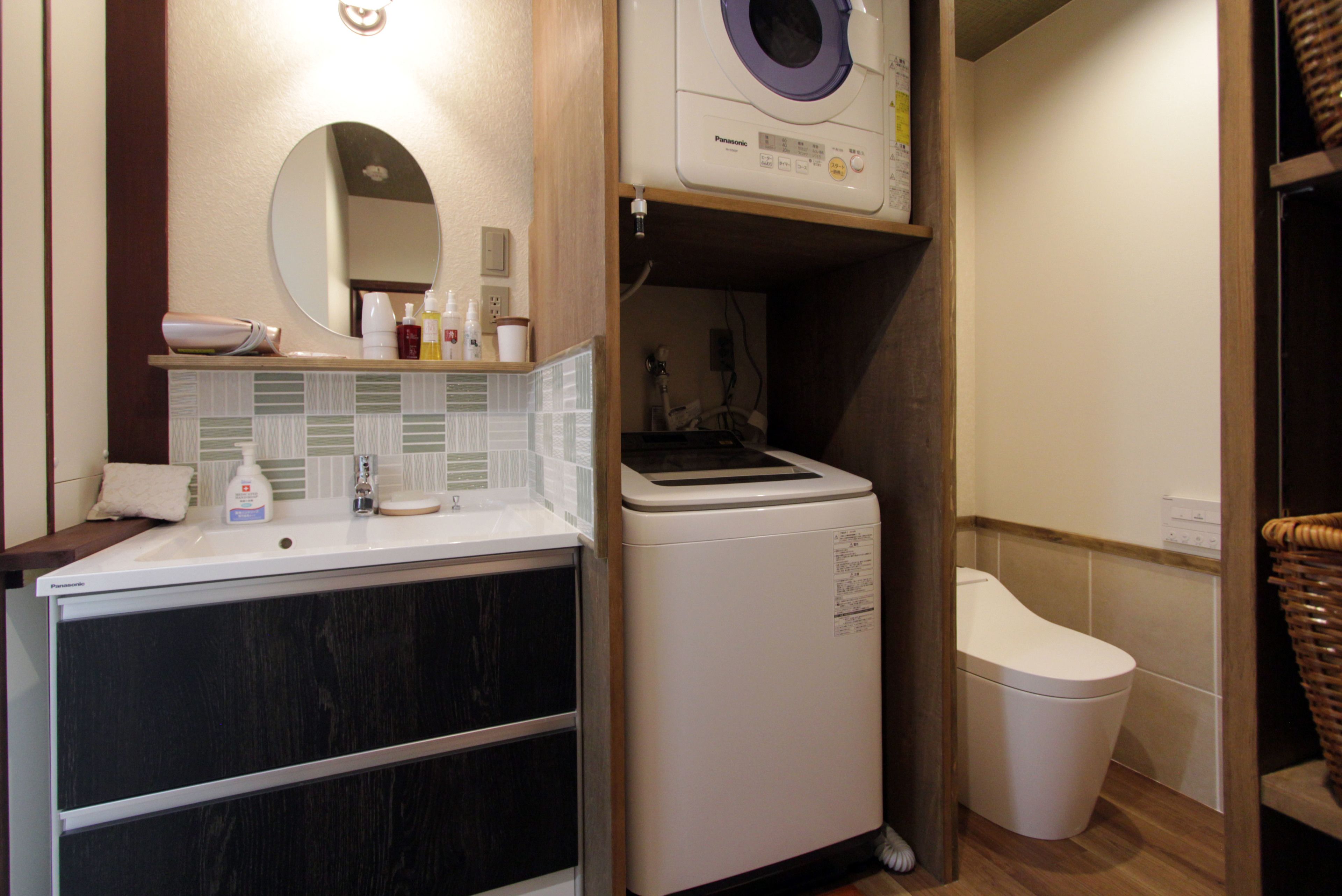 Une petite salle de bain comprenant un lavabo, un miroir et un lave-linge.