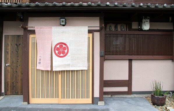 A traditional Japanese gate with a wooden door and a sliding paper screen.