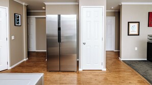 A modern kitchen with stainless steel appliances, wooden flooring, and white cabinetry. - Quiet Napier Retreat, close to the off-road trails (Taradale)