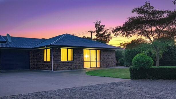 A two-story stone house with a garage, a driveway, and a well-maintained lawn. - Quiet Napier Retreat, close to the off-road trails (Taradale)
