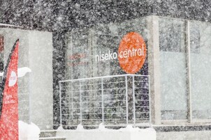 Un bâtiment sur lequel on peut lire l’inscription « Nisekon Central », au milieu d’une forte chute de neige.