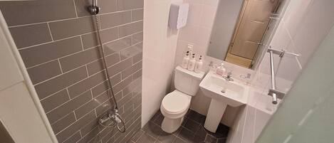 A bathroom with a shower, toilet, and sink.