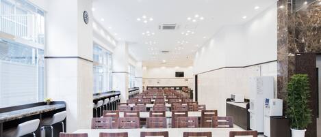 A conference room with rows of chairs, a long table, and a reception desk.