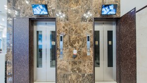 An elevator with marble walls and two digital displays at the top. - Toyoko Inn Nagoya Meieki Minami (Nagoya)