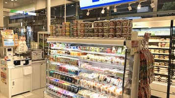 A FamilyMart store with refrigerated sections for beverages and snacks, a checkout area, and a freezer section.