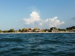 Une zone côtière avec des bâtiments aux toits de chaume et une plage.
