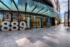 A modern building with large glass windows and a prominent '889' sign on the facade. - APC on Collins (Docklands)