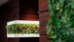 Ein modernes Interieur mit einer Wandpaneele aus Holz und einer hängenden Blumenkomposition.