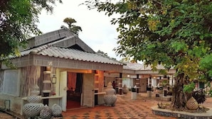 A traditional building with a tiled courtyard, featuring a checkered floor pattern and decorative spherical objects near the entrance. - I am Chiangrai (Chiang Rai)