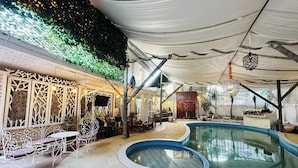 An indoor pool area with a white canopy, seating, and a decorative wall. - I am Chiangrai (Chiang Rai)