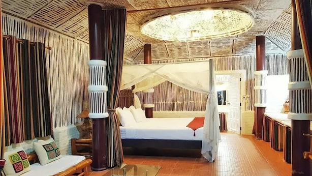 A room with a bed, a sofa, a glass coffee table, and a large window. - I am Chiangrai (Chiang Rai)