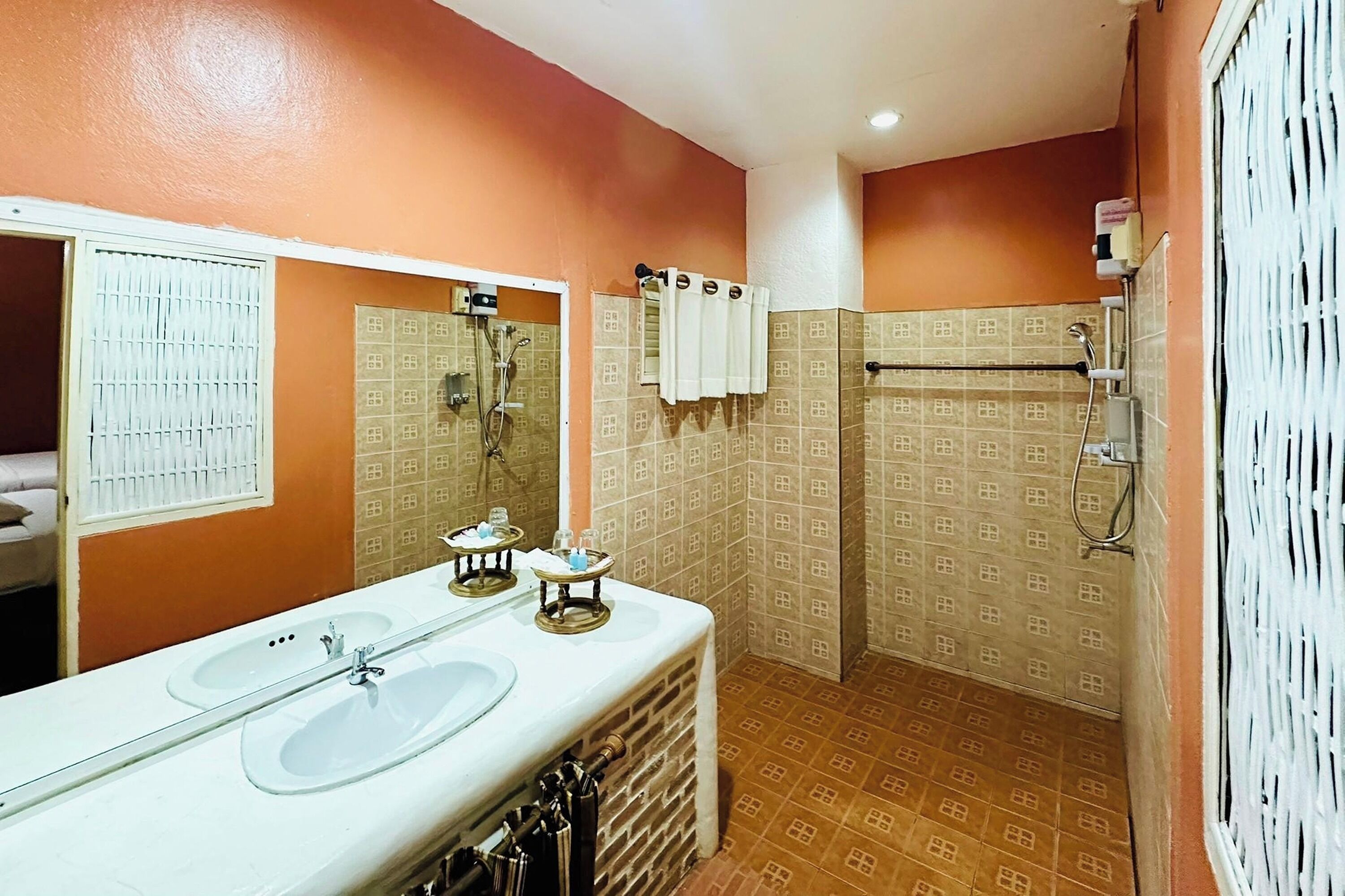 Un baño con dos lavamanos, ducha y barra para toallas.