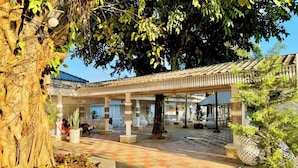 A covered outdoor area with a tiled floor, a pergola structure, and potted plants. - I am Chiangrai (Chiang Rai)