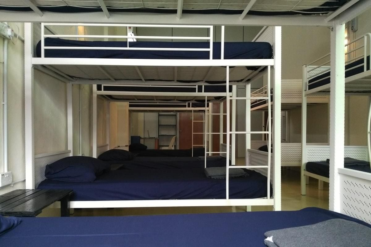 Un dormitorio con literas, un escritorio y una ventana.