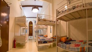 A dormitory room with bunk beds, a fire extinguisher, and a ceiling light fixture. - Vloft Backpackers Hostel (Ipoh)