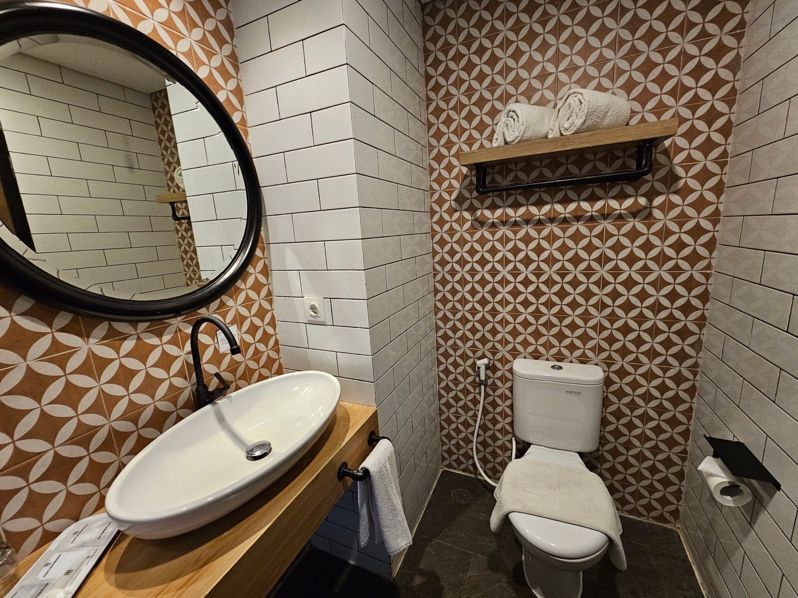 A bathroom with a white sink, a mirror, a toilet, and a towel rack.