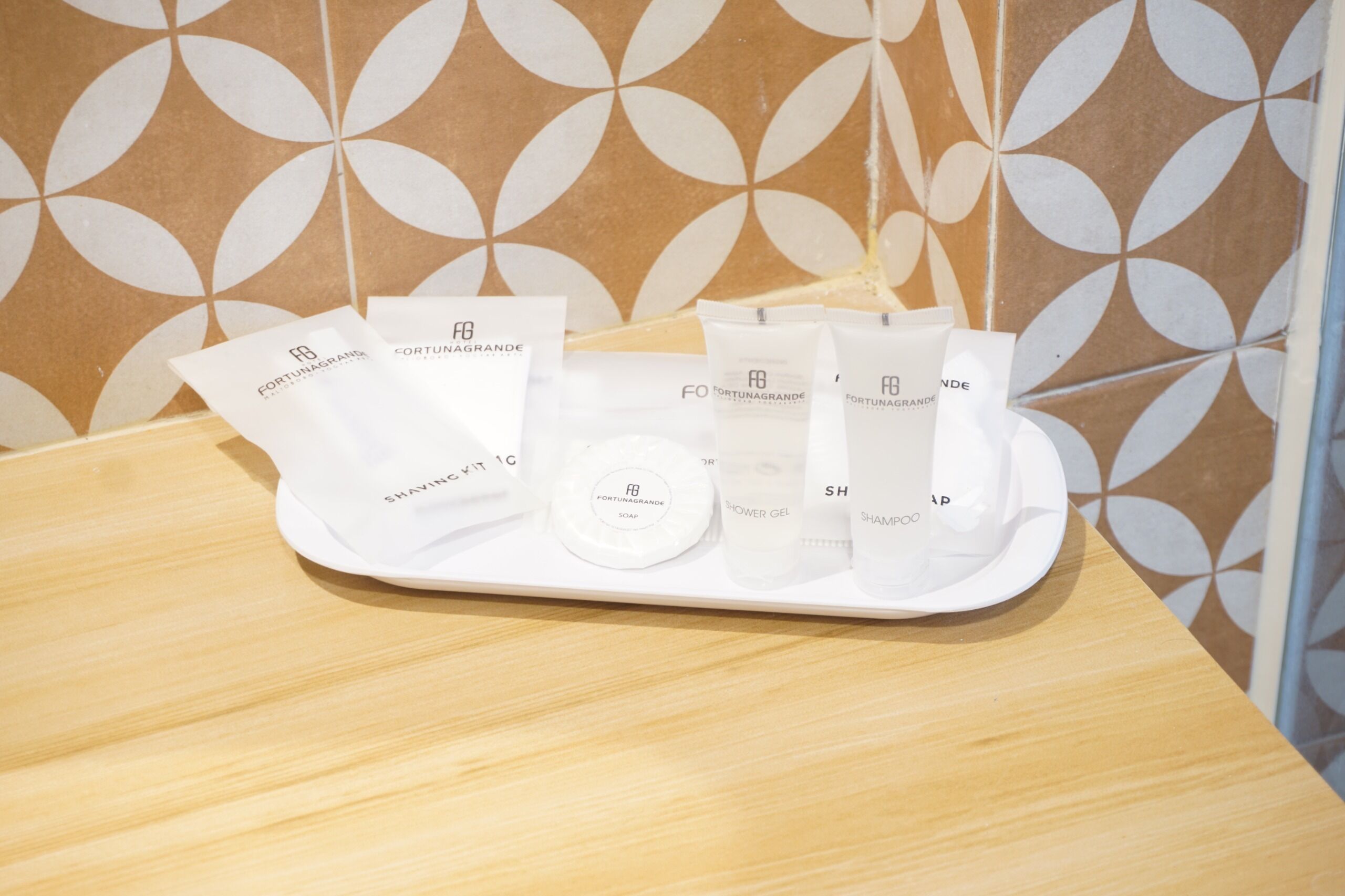 A tray with various toiletries including a shaving kit, soap, and shower gel.