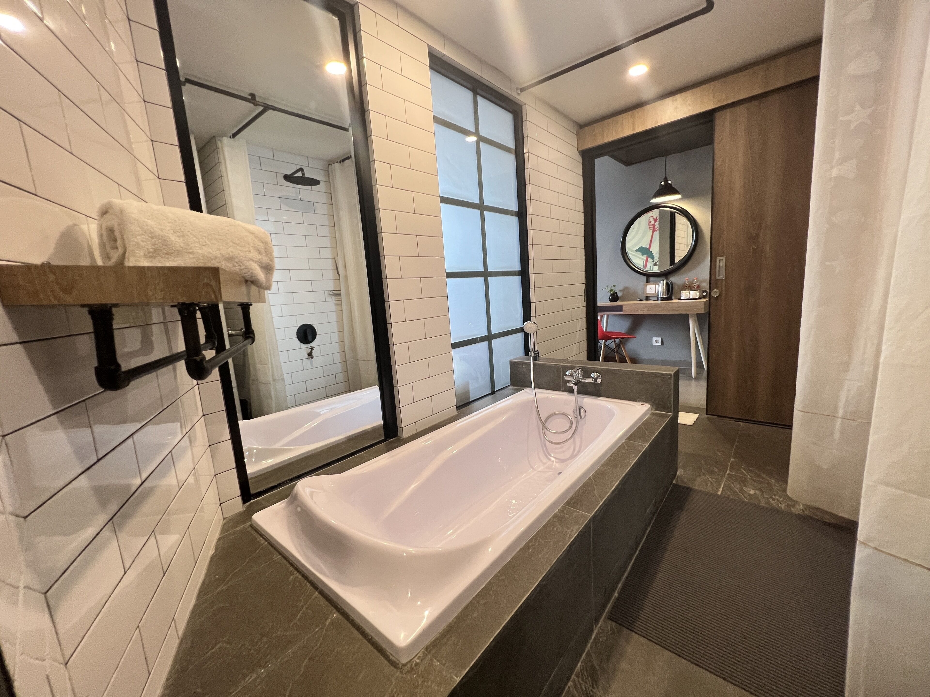 Une salle de bain moderne avec une grande baignoire, une douche et un meuble-lavabo avec un miroir.
